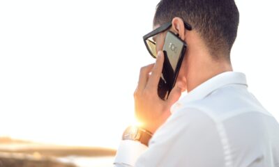 shallow focus photography of a man in white collared dress shirt talking to the phone using black android smartphone