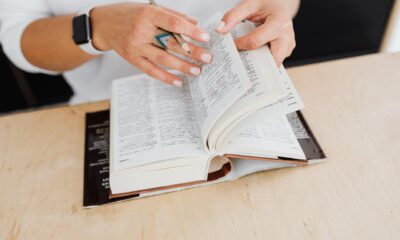 person wearing silver ring holding white book page